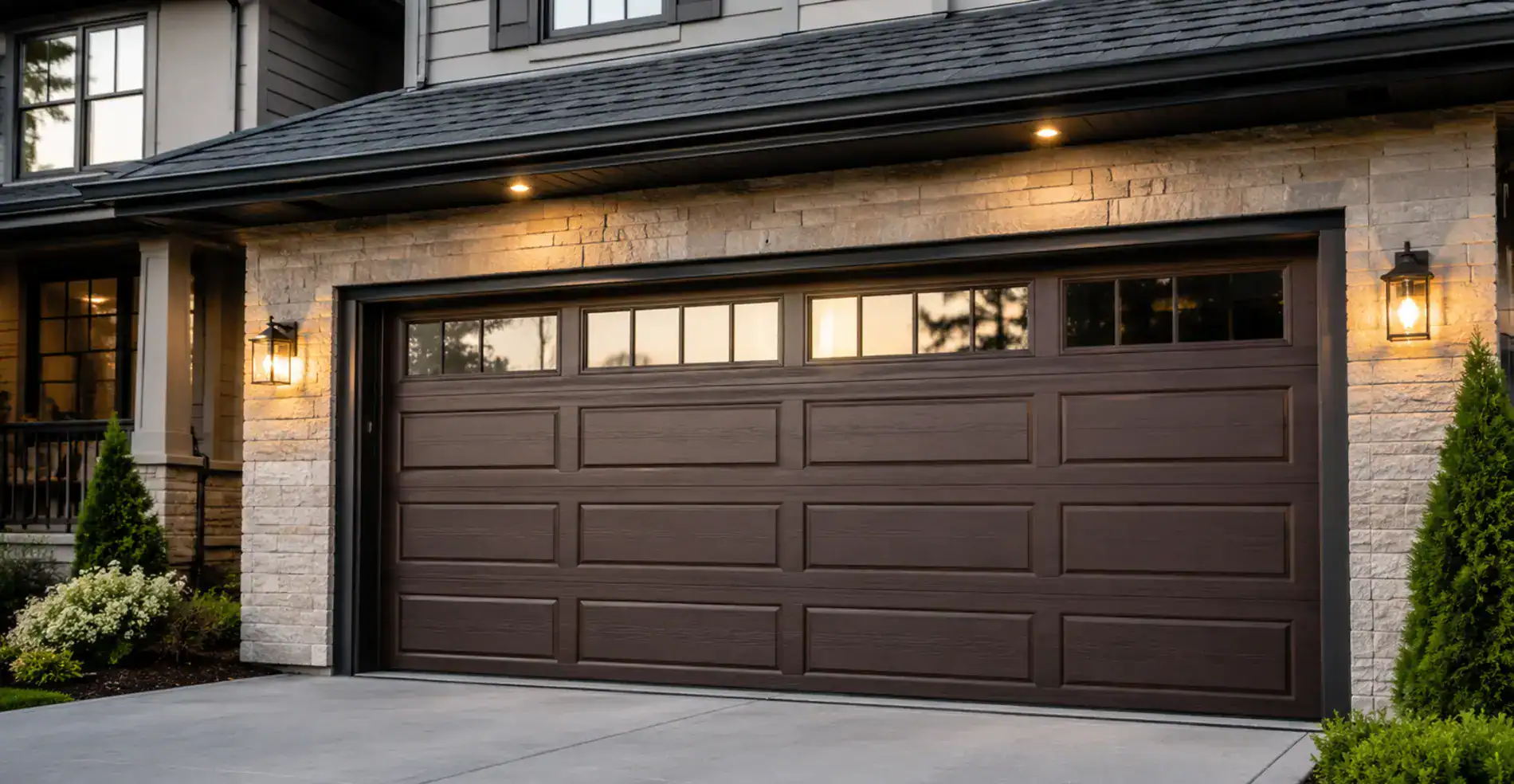 Contemporary brown garage door with windows and exterior lighting, enhancing curb appeal and security.