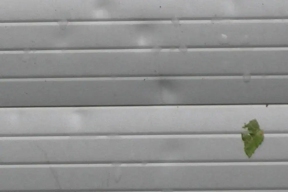 Hail damage dents on a metal garage door panel
