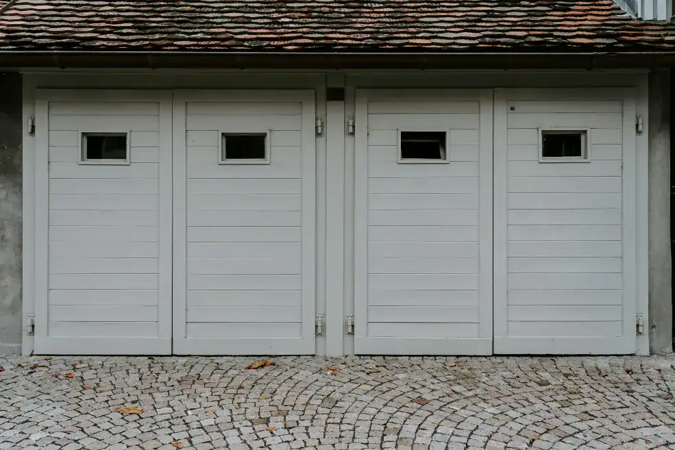 Traditional white swing-out carriage house doors with small windows