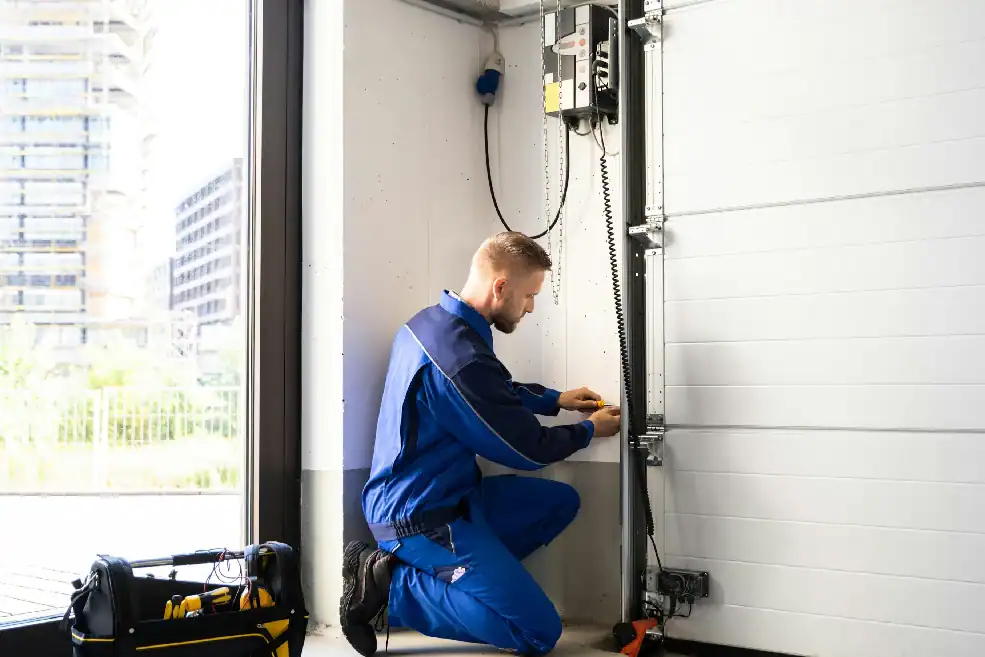 man inspecting a garage door sensor.webp