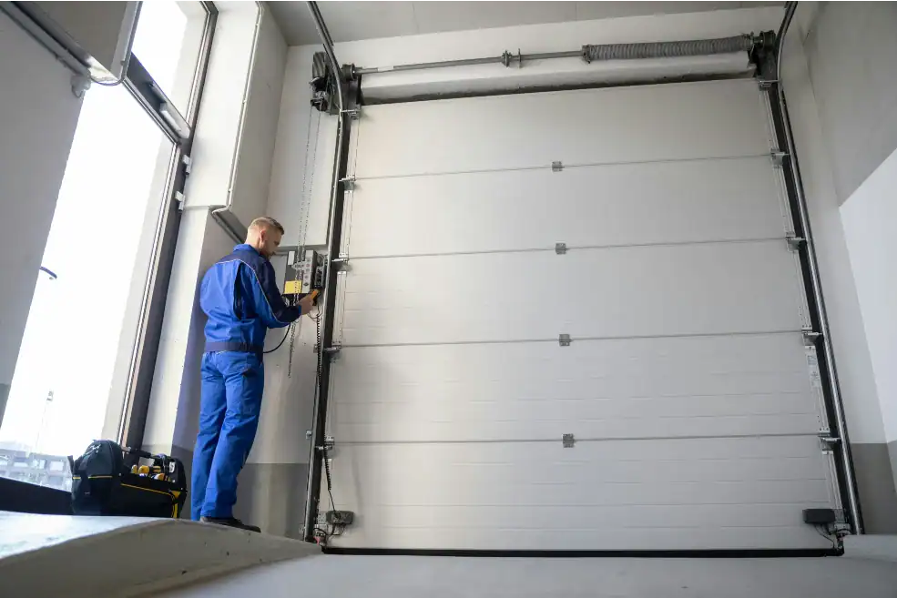man inspecting garage door control panel